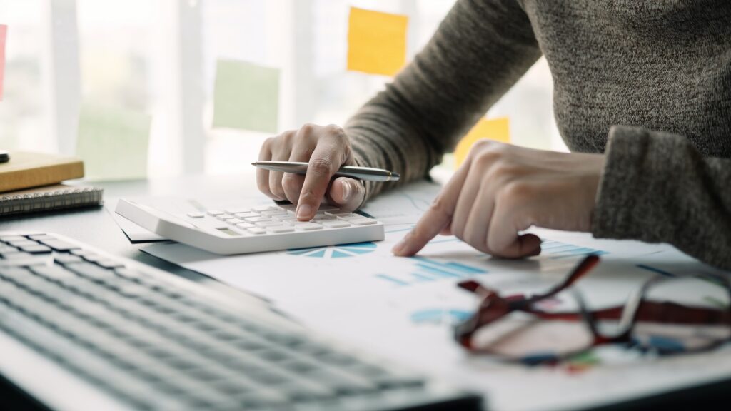 Close up view of bookkeeper or financial inspector hands making report, calculating or checking
