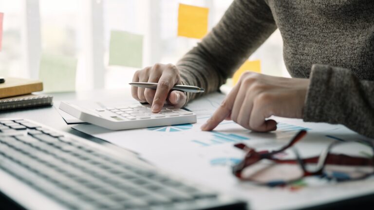 Close up view of bookkeeper or financial inspector hands making report, calculating or checking